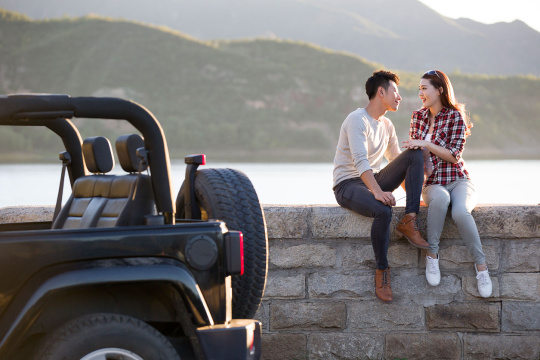 年轻情侣开吉普车出游