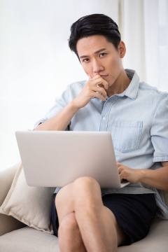 年轻男士在客厅使用笔记本电脑