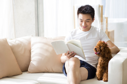 年轻男子在沙发上看书