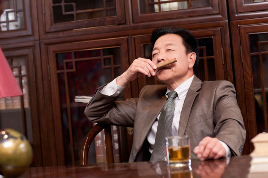 成功的商务男士闻雪茄