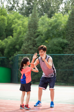 快乐的父女俩在运动场打篮球