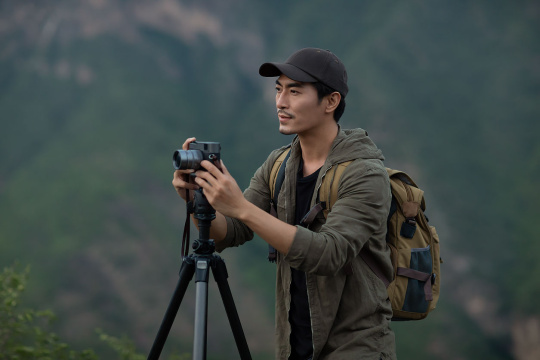 年轻男士在户外使用相机拍照