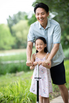 父女俩人在公园玩滑板车