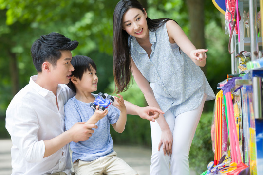 父母和儿子在玩具摊挑选玩具