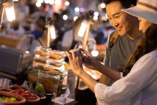 快乐的年轻情侣逛街头集市