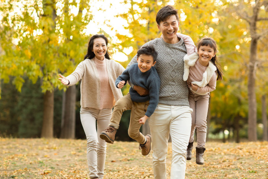 快乐的年轻家庭在树林里玩耍