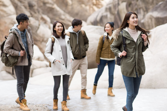 Happy young Chinese friends enjoying winter outing