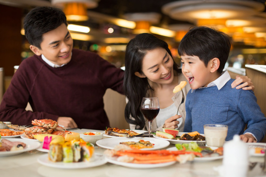 开心的年轻家庭新年吃自助餐