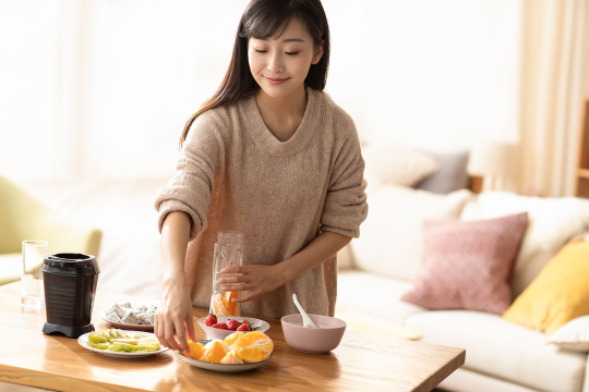 年轻女士在家榨果汁