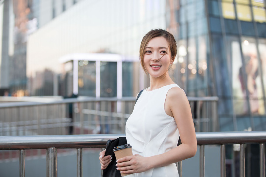 自信的年轻商务女子拿着一杯咖啡