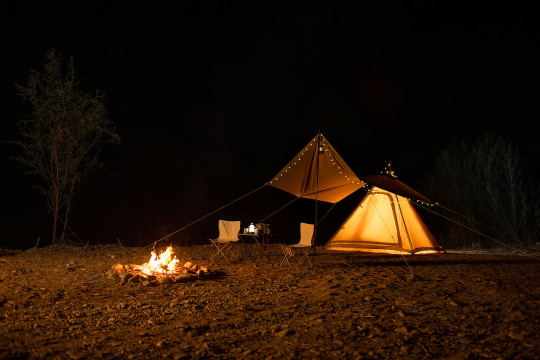 夜幕下的露营帐篷和篝火