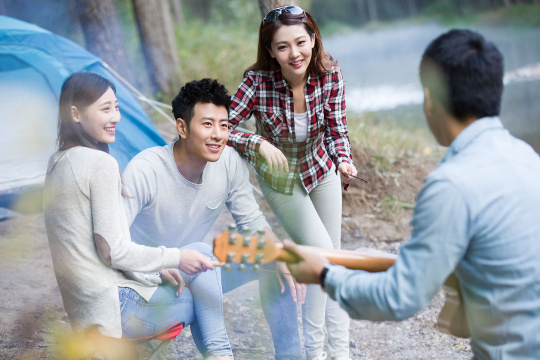 年轻人围着营火弹吉他