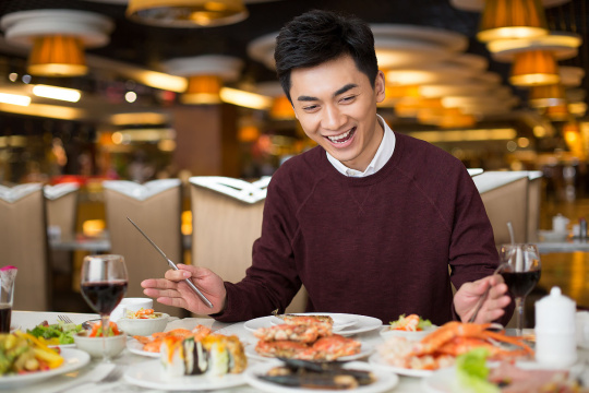 开心的年轻男子新年吃自助餐