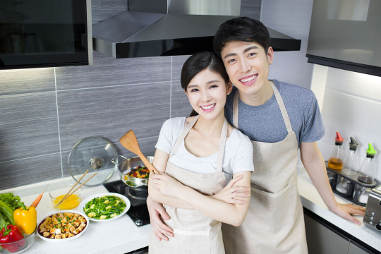 快乐的年轻夫妇在厨房做饭