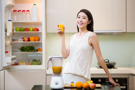 年轻女子拿着一杯鲜榨果汁