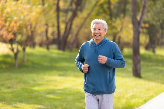 开心的老年男子在公园跑步