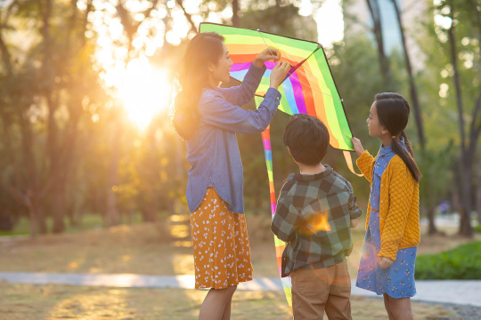 快乐的年轻家庭在公园放风筝