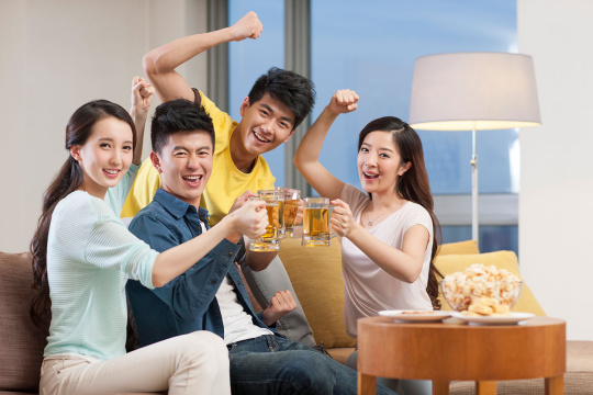 年轻人喝啤酒看体育比赛