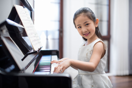 快乐的小女孩弹钢琴