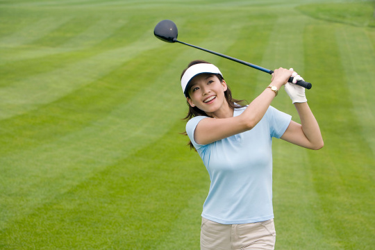 挥杆的高尔夫女球手