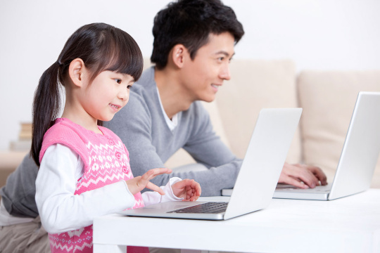小女孩和爸爸用笔记本电脑上网