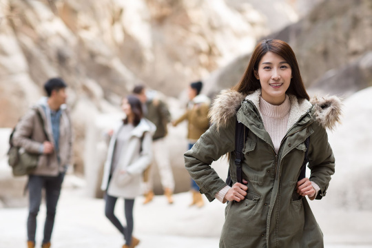 Portrait of cheerful young Chinese woman outdoors in winter