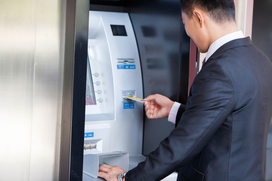 商务男士使用自动取款机