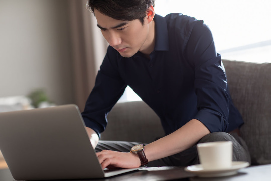 年轻商务男士酒店使用笔记本电脑