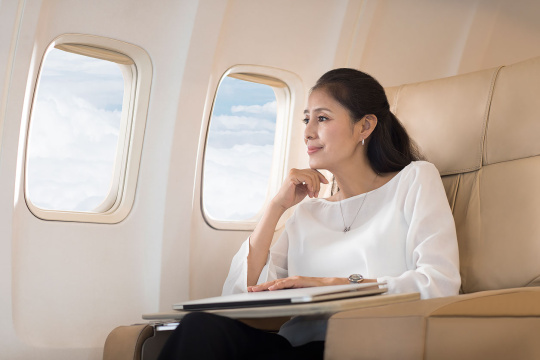 优雅的中年女士欣赏飞机窗外的风景