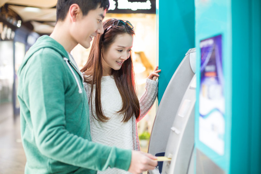 年轻情侣使用自动取款机