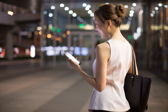 开心的年轻商务女子使用手机