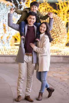 开心的年轻家庭春节户外赏彩灯