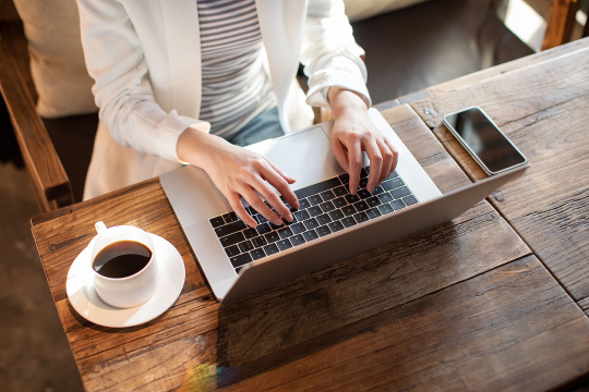 年轻商务女士在咖啡店使用电脑