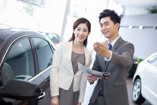年轻商务女士在4S店选购汽车
