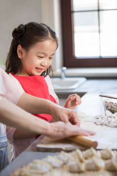 快乐的奶奶和孙女在厨房包饺子