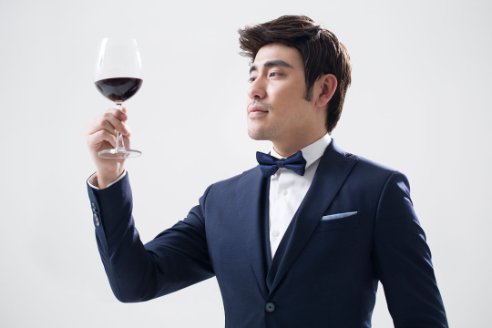 优雅的年轻男子品尝红酒