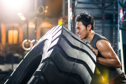 年轻男子在健身房做翻轮胎训练