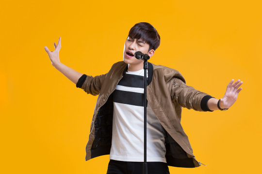 快乐男生拿着麦克风唱歌