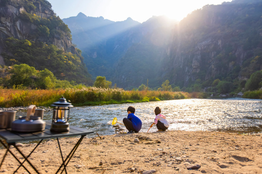 快乐的兄妹俩在河边捞鱼