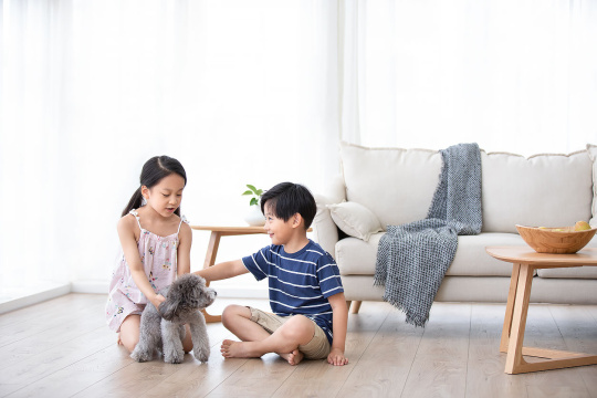 兄妹俩在家和狗玩耍