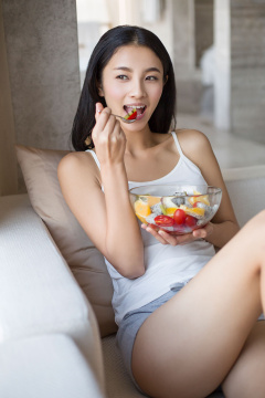 年轻女子吃水果沙拉