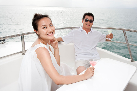 中年夫妇在游艇上喝鸡尾酒