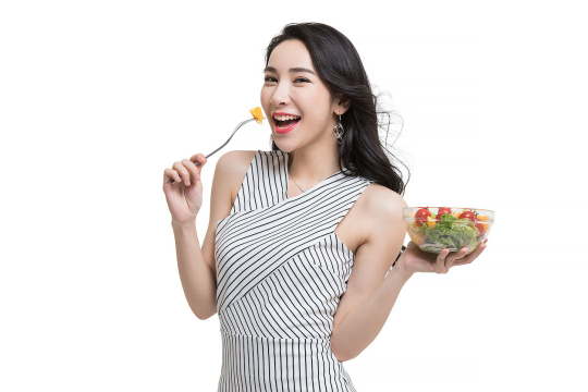 年轻时尚女性吃蔬菜沙拉