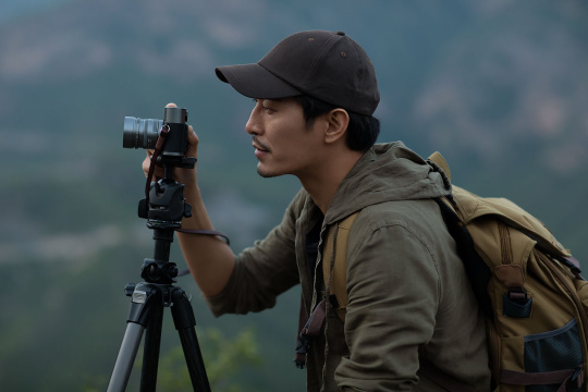 年轻男士在户外使用相机拍照