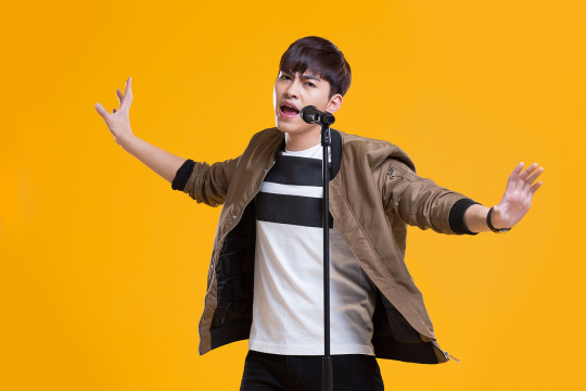 快乐男生拿着麦克风唱歌