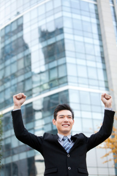 青年商务男士举起双臂庆祝