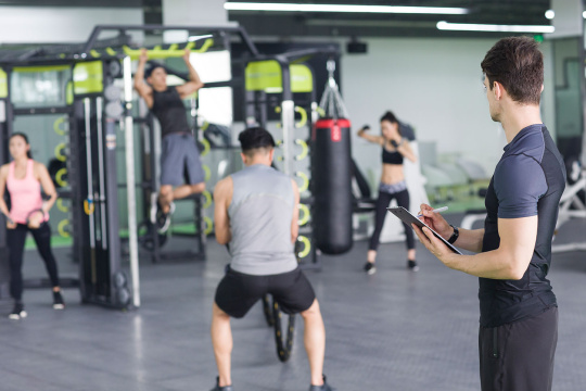 健身教练观察学员的健身动作