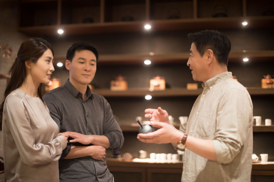 茶具老板向顾客展示茶壶