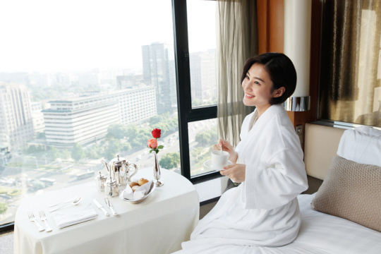 年轻女人在酒店房间里喝咖啡