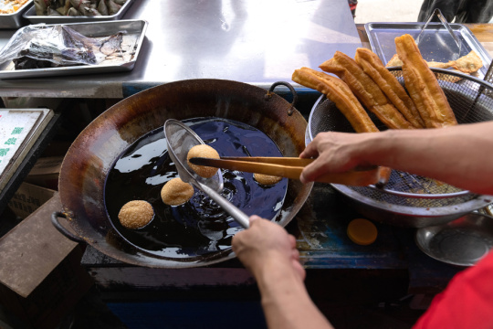 商贩炸制麻团油条